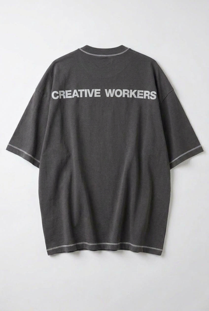 Back view of a gray oversized tee featuring the text 'CREATIVE WORKERS' for stylish comfort.